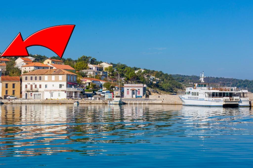 a boat in the water next to a town at DAKOVIC DENI in Šilo