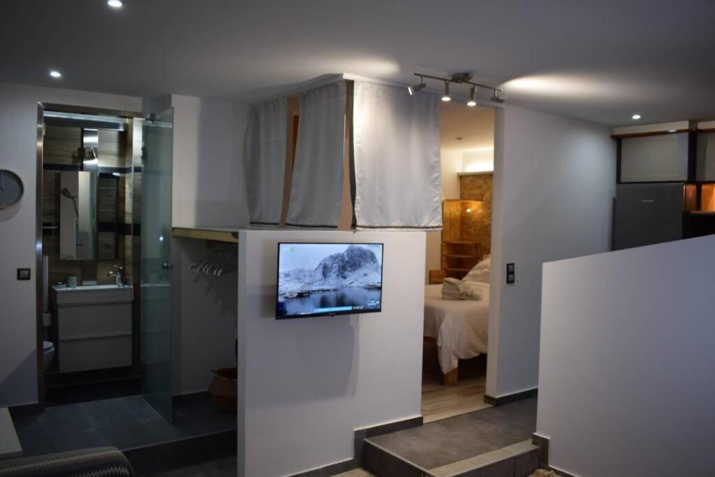 uma cozinha com uma televisão numa parede num quarto em 3h Anthi Comfort apt near Athens em Atenas