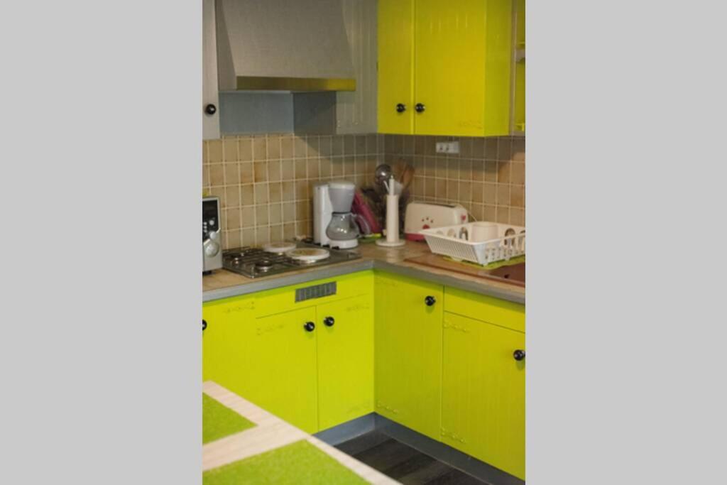 a kitchen with bright yellow cabinets and green counters at Entre parc et Haras in Hennebont