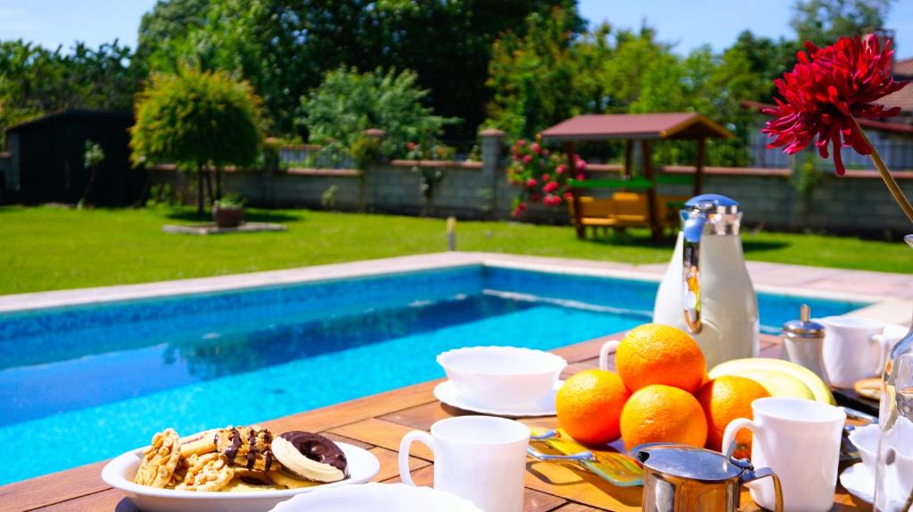 a table with fruit on it next to a pool at Вила Релакс - Villa Relax in Sokolovo