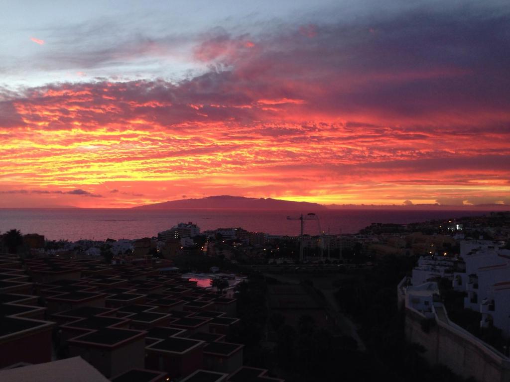 a sunset over a city with a mountain in the background at Dream View in Adeje