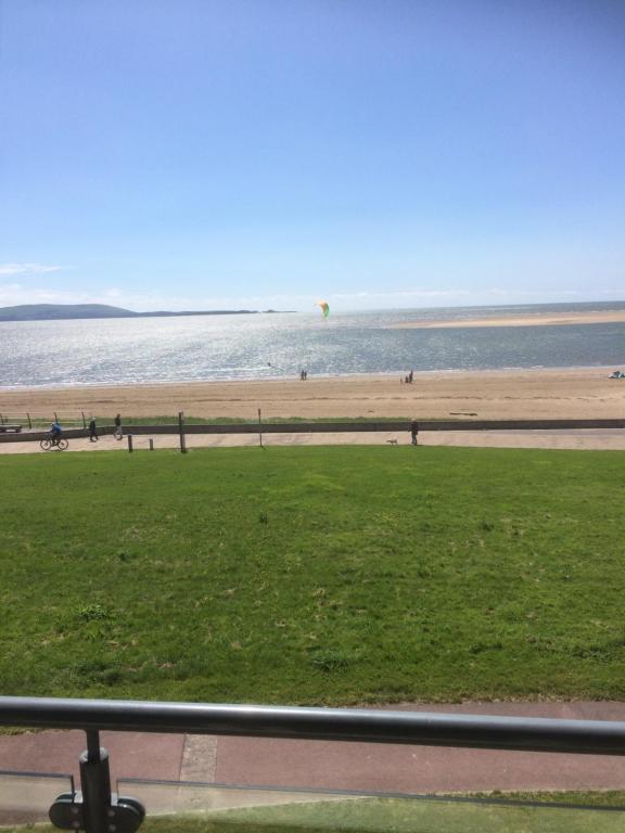 a view of a beach and the ocean with people at Bay View in Llanelli