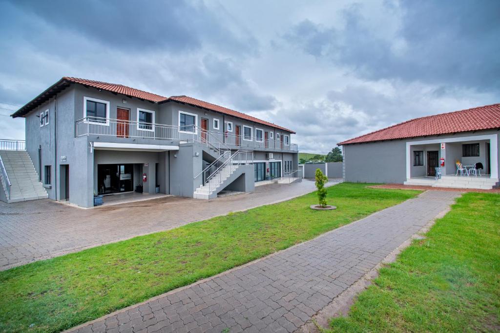 un gran edificio con un patio de césped delante de él en Khayalami Hotel - Emalahleni, en Witbank