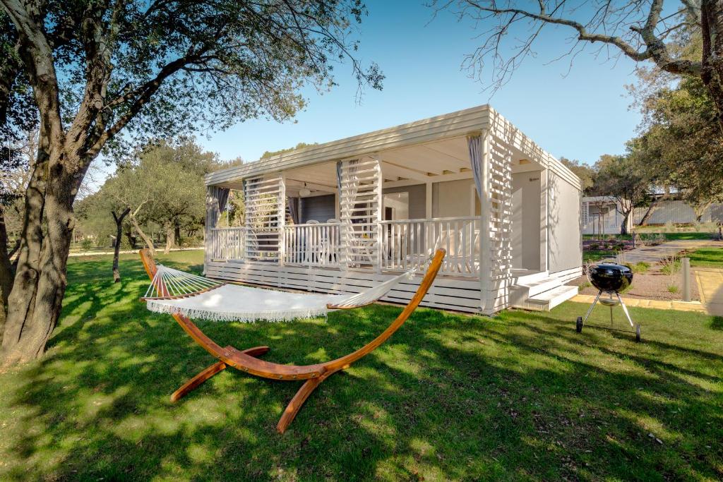 a hammock in front of a tiny house at Maistra Camping Amarin Mobile homes in Rovinj