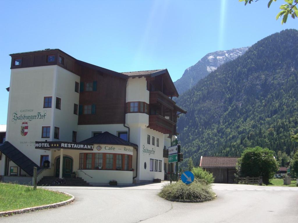 un grand bâtiment avec une montagne en arrière-plan dans l'établissement Salzburgerhof Jugend- und Familienhotel, à Lofer