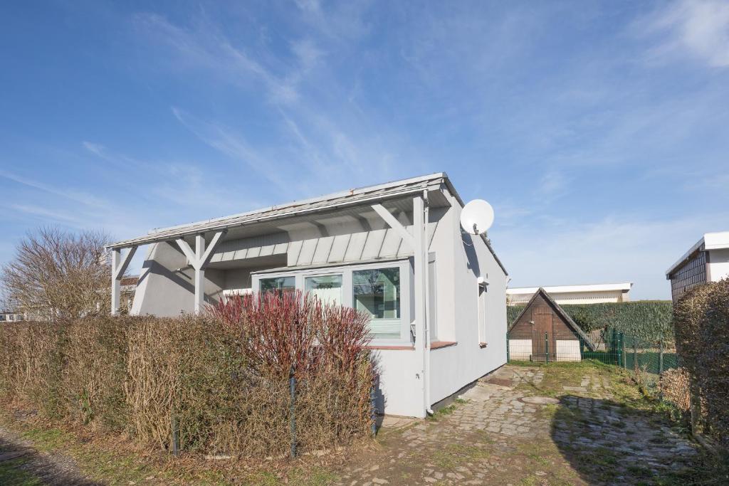 una pequeña casa blanca pequeña con ventana en Ferienhaus Rügenblick en Stahlbrode