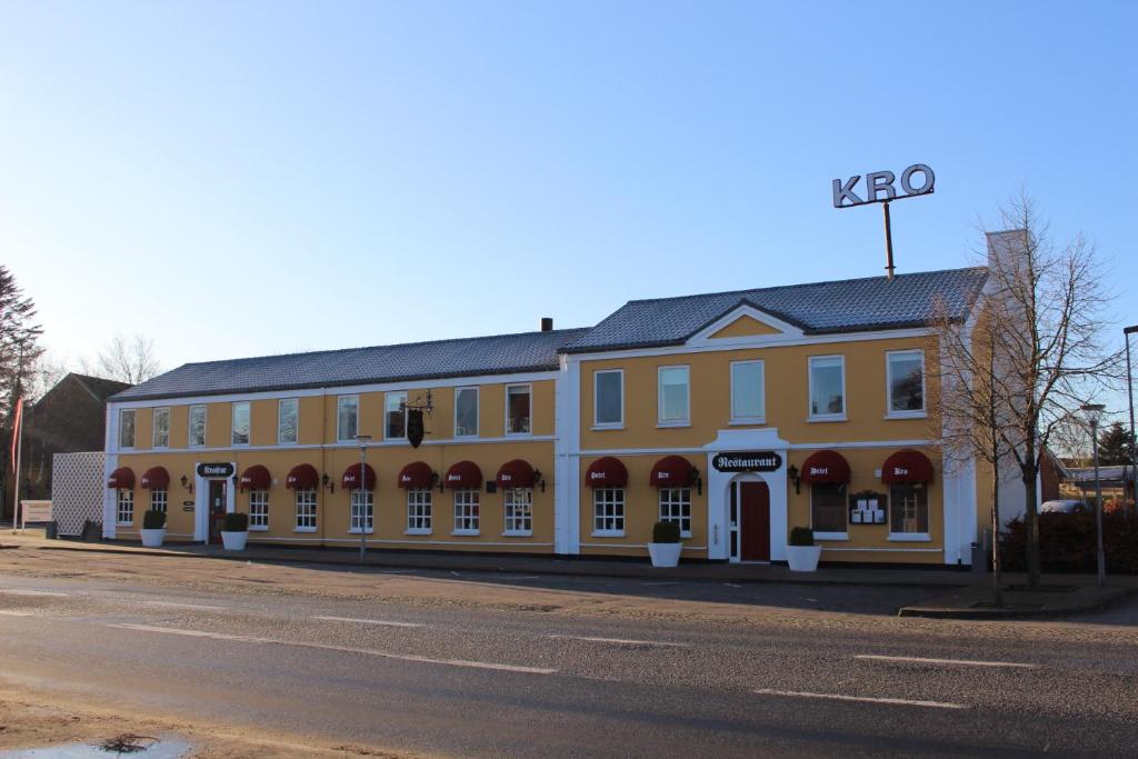 a yellow building on the side of a street at Auning Kro in Auning