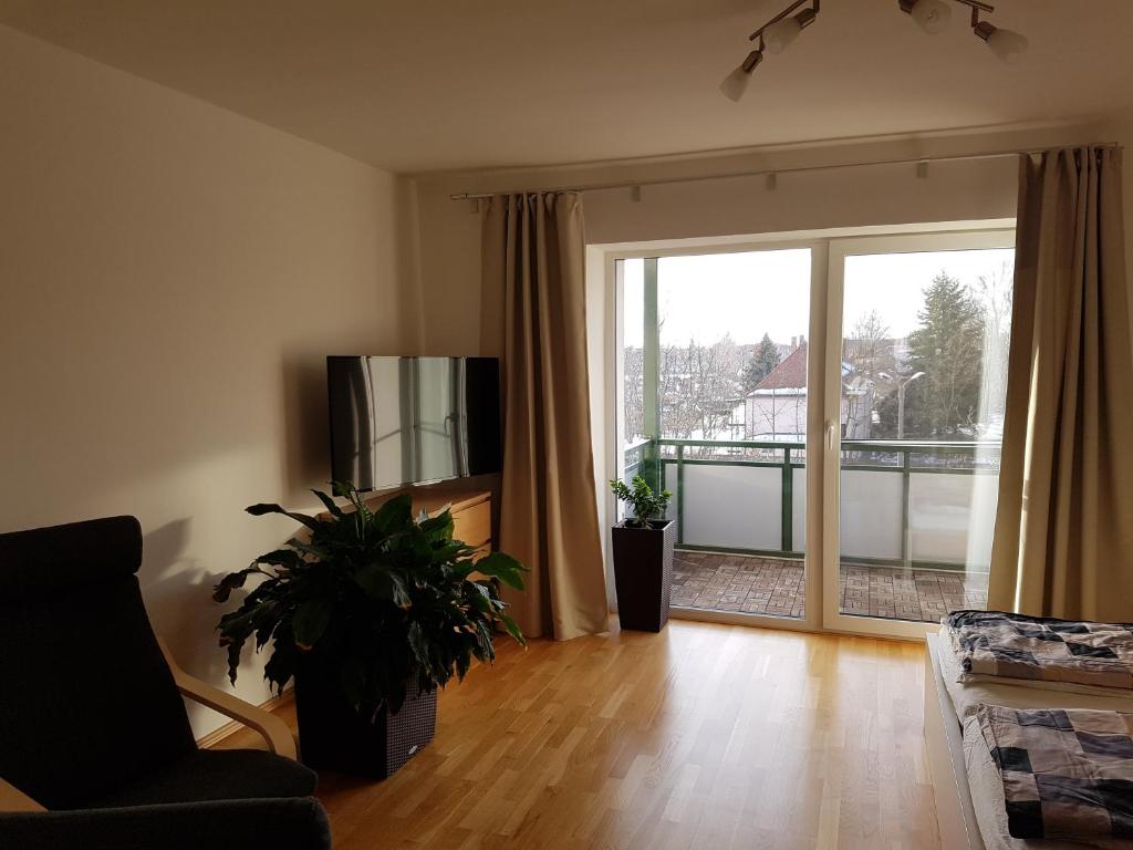 - un salon avec un canapé, une télévision et une plante dans l'établissement Fewo Dresden-Trachau, à Dresde