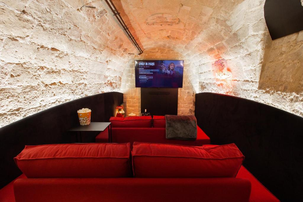 a room with red couches and a flat screen tv at CMG Jacques /Pantheon in Paris