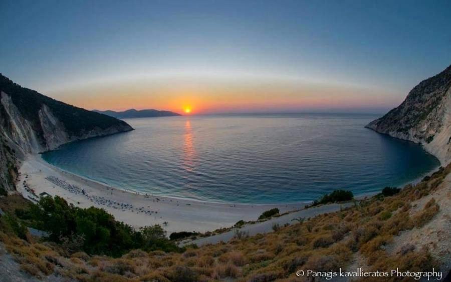 a view of a beach with the sun setting over the water at Fantastic Matala 1 in Matala