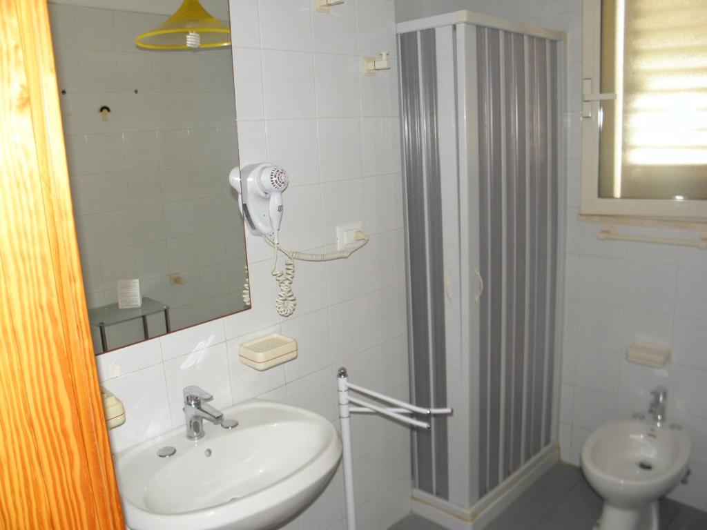 a bathroom with a sink and a shower and a toilet at Hotel Blue Sky - San Foca in San Foca