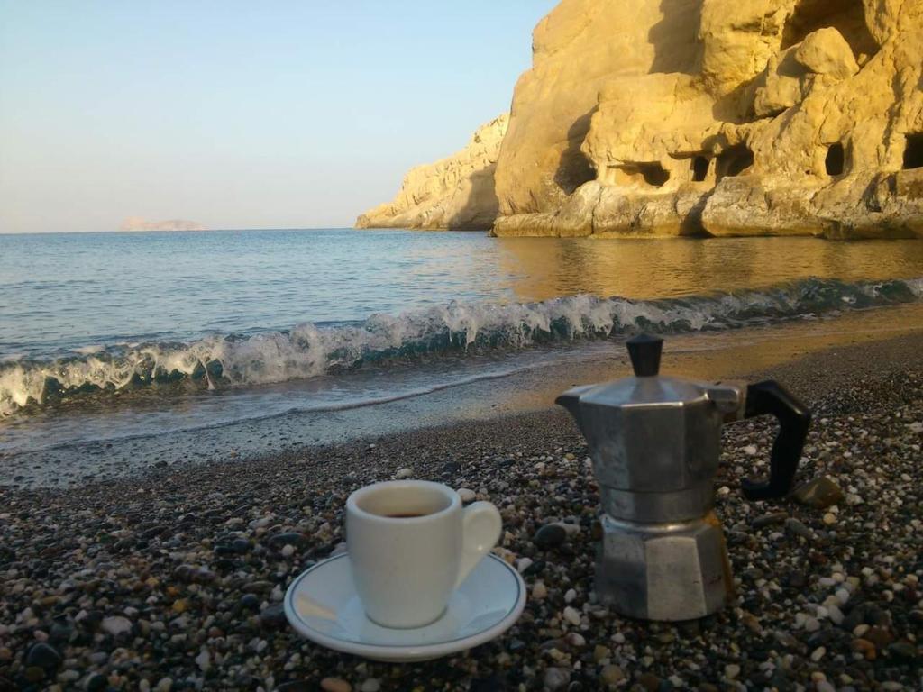 a cup of coffee and a kettle on a beach at Fantastic Matala 1 in Matala
