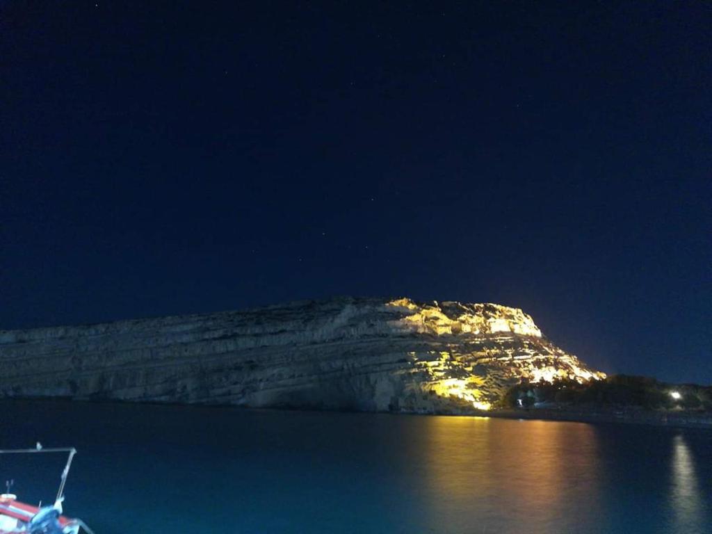 a boat in a body of water at night at Fantastic Matala 1 in Matala