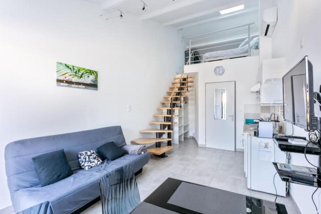 Studio meublé في Saint-André-de-Sangonis: غرفة معيشة مع أريكة زرقاء ودرج