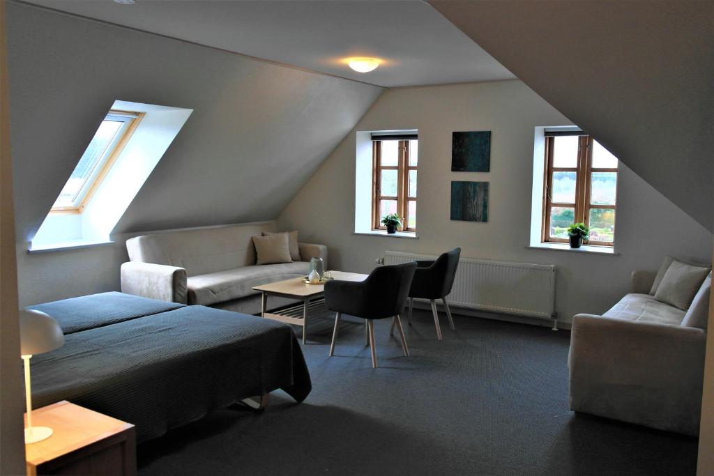 a room with a bed and a couch and windows at Skjoldbjerg Garnihotel in Vorbasse