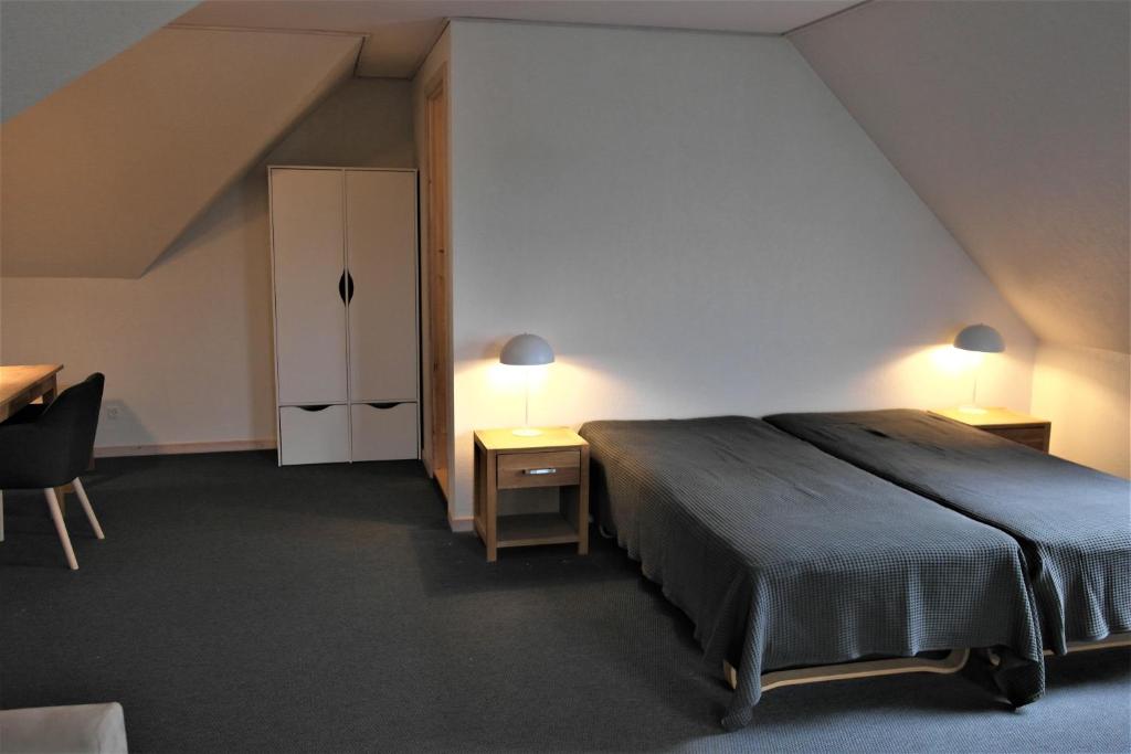 a bedroom with a bed and a desk and a closet at Skjoldbjerg Garnihotel in Vorbasse