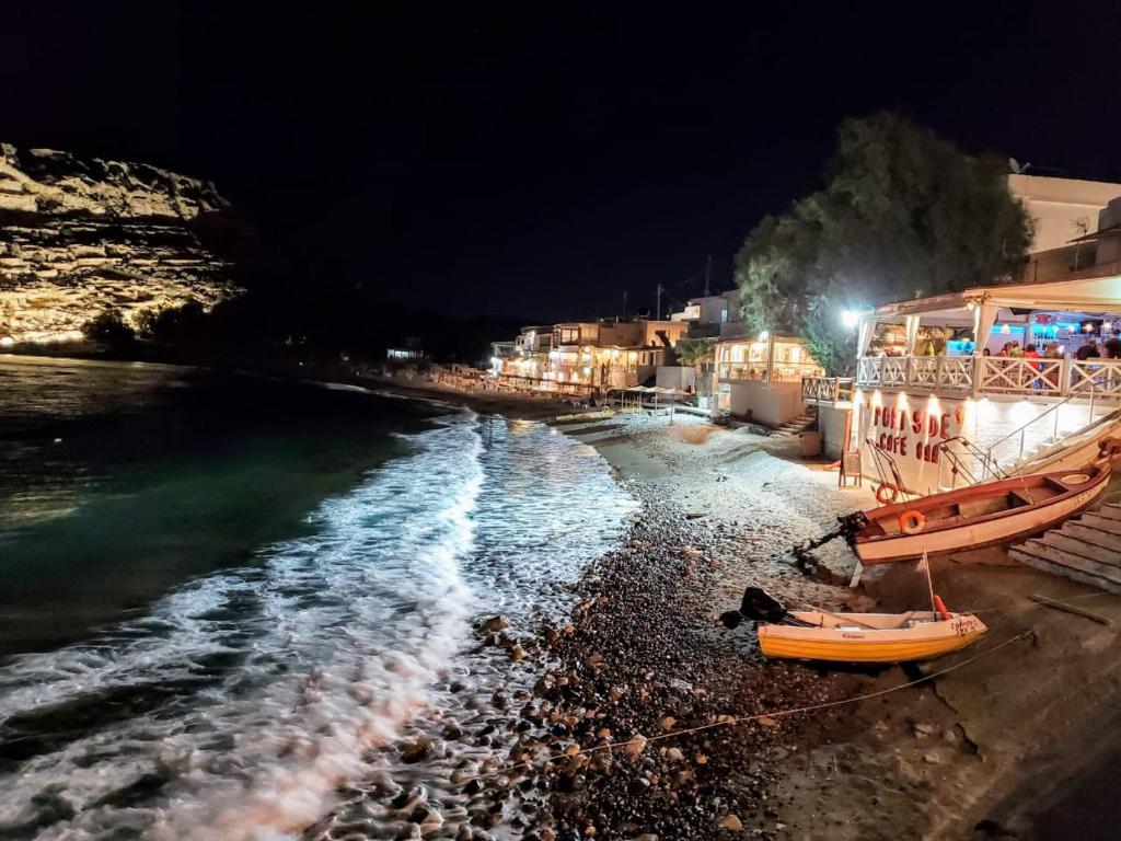 a beach at night with a boat on the shore at Fantastic Matala 1 in Matala
