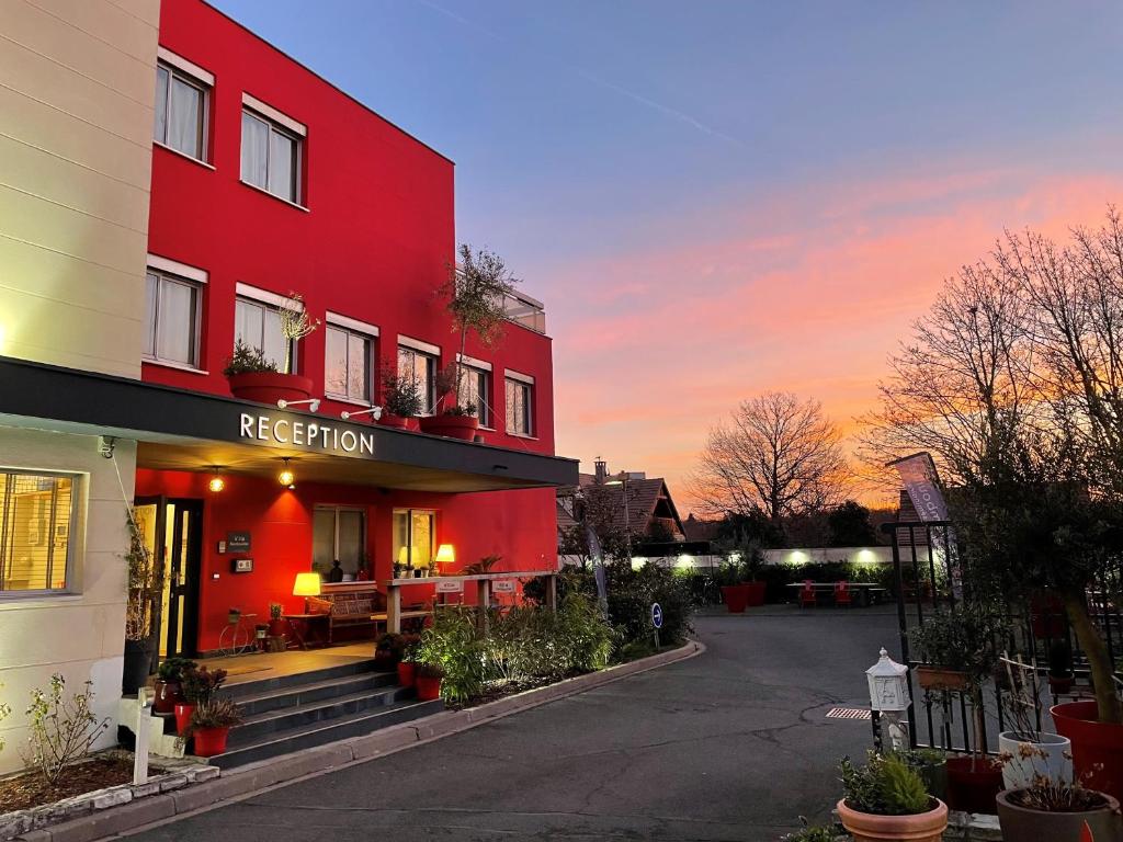ein rotes Gebäude mit einer roten Fassade mit Sonnenuntergang in der Unterkunft Villa Rambouillet in Rambouillet