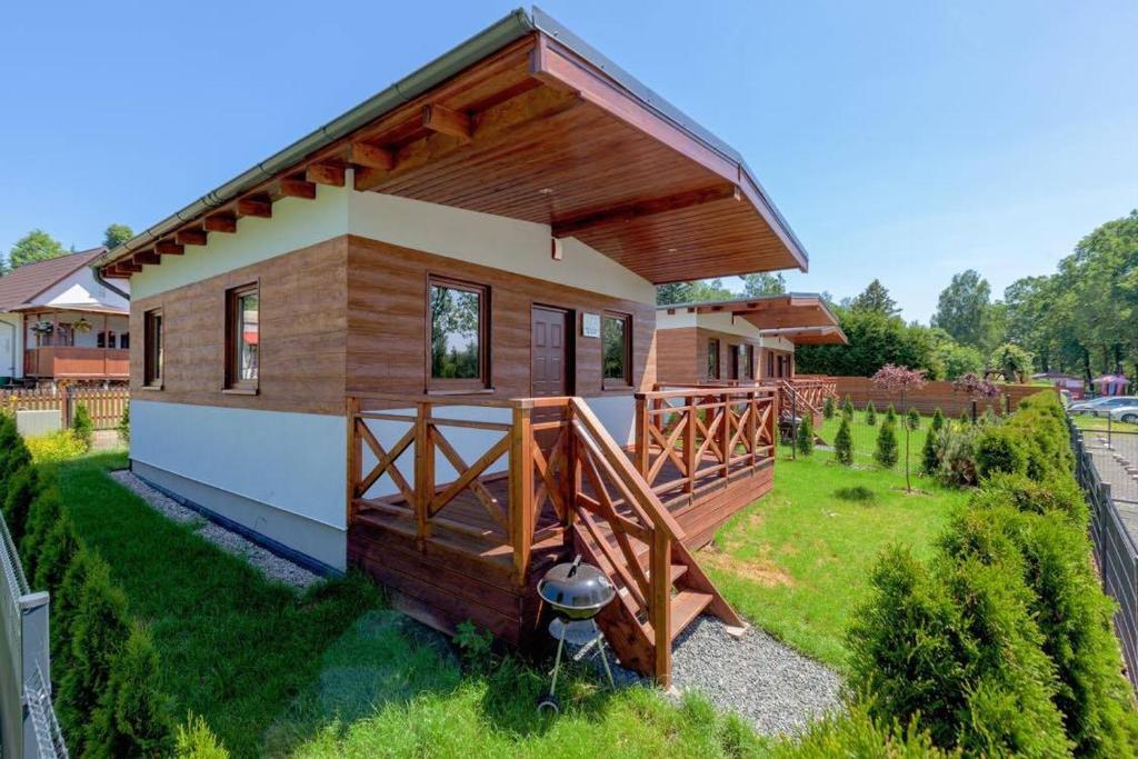 een klein huis met een groot terras in de tuin bij Domki Bożkowice in Bożkowice