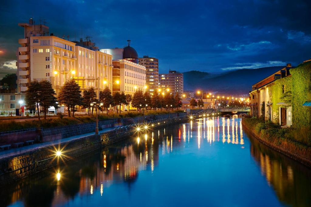 a river in a city at night with buildings at Hotel Sonia Otaru in Otaru