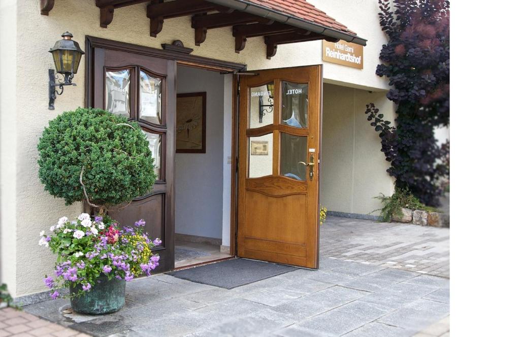 a wooden door of a house with flowers in a vase at Hotel Reinhardtshof Garni in Wolfschlugen