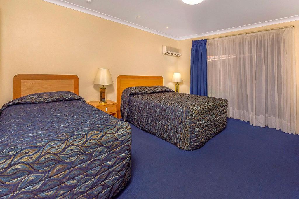 ein Hotelzimmer mit zwei Betten und einem Fenster in der Unterkunft Comfort Inn Bay of Isles in Esperance