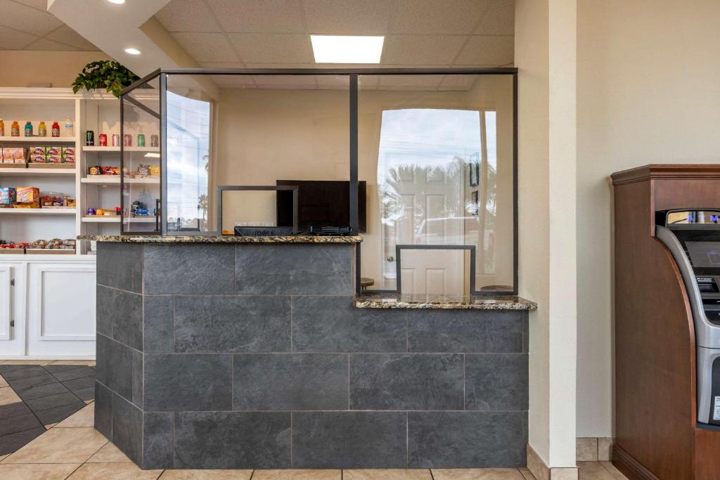 a kitchen with a stone counter with a tv at Econo Lodge Inn & Suites Maingate Central in Kissimmee