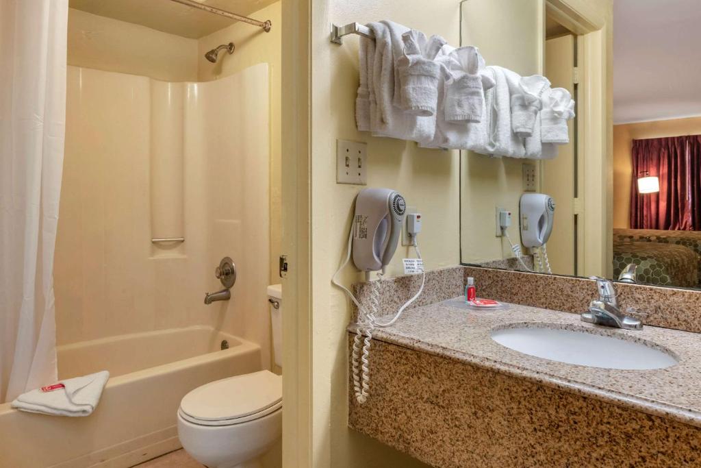 a bathroom with a sink and a toilet and a phone at Econo Lodge Inn & Suites Maingate Central in Kissimmee