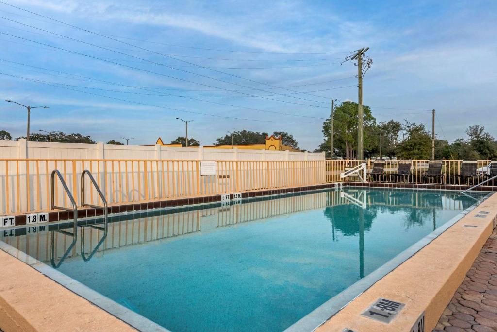a swimming pool with blue water in front of a fence at Econo Lodge Inn & Suites Maingate Central in Kissimmee