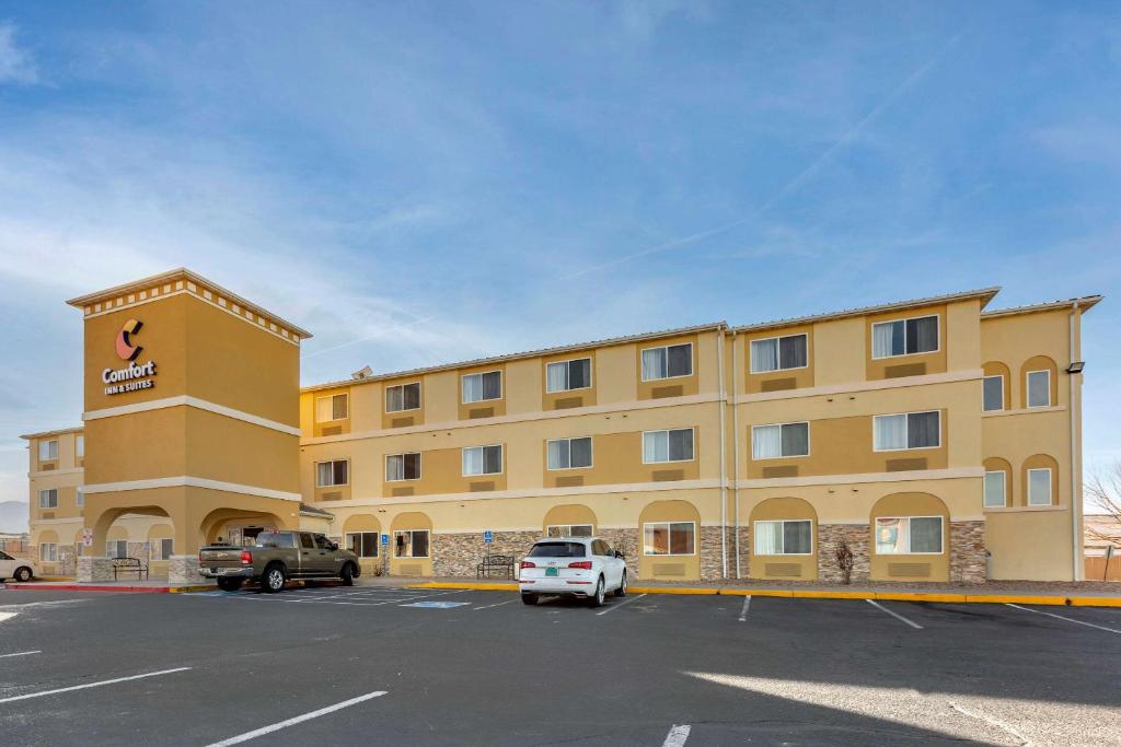 un gran edificio amarillo con un coche aparcado en un aparcamiento en Comfort Inn & Suites Alameda at Albuquerque Balloon Fiesta Park, en Albuquerque