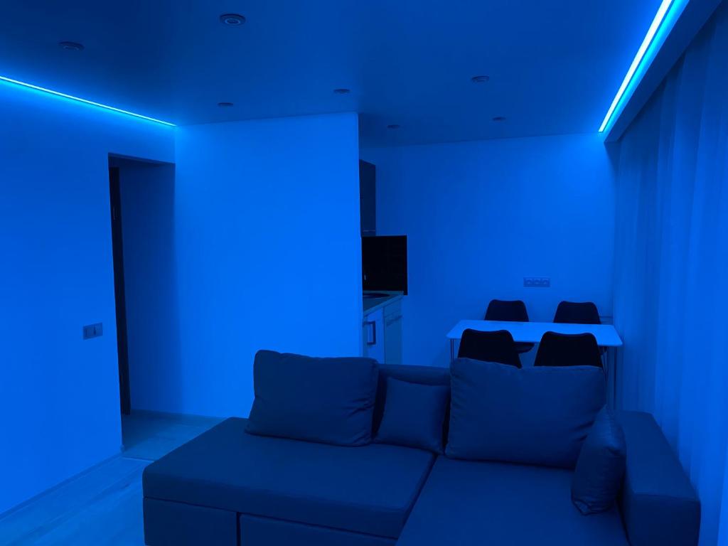 um quarto azul com um sofá e uma luz azul em Апартаменты Бульвар Славы 21 em Dnipro