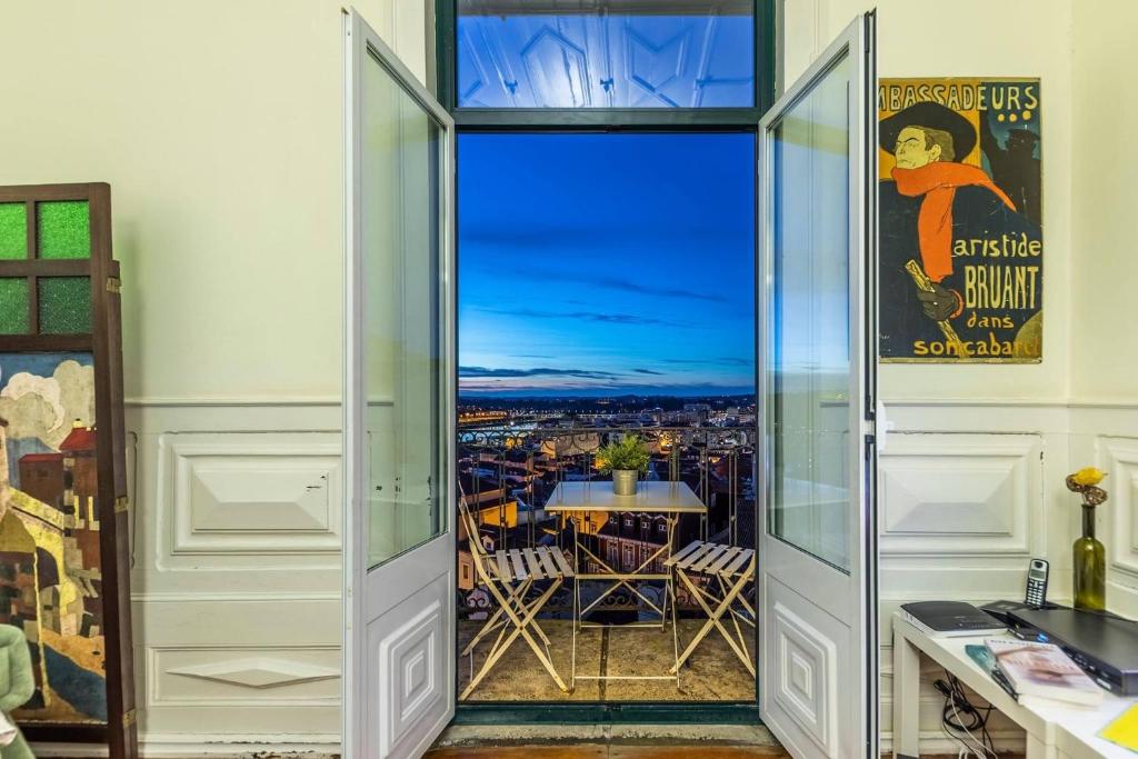 a room with a door open to a balcony with a view at Casa da Carqueja in Coimbra