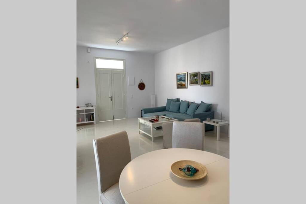 a living room with a table and a blue couch at Ευημερία in Andros
