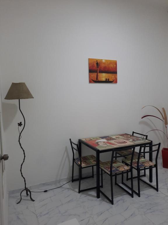 una mesa con sillas y una lámpara en una habitación en Departamento Malbec Mendoza en Mendoza
