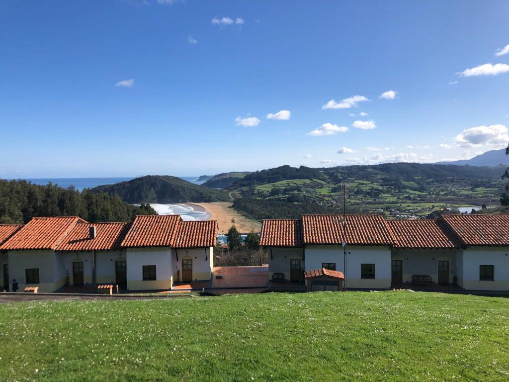 una fila de casas con montañas en el fondo en Apartamentos Monterodiles, en Liñero