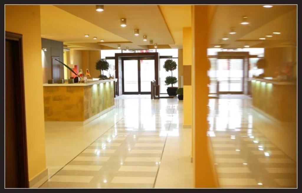 a hallway of a building with yellow walls and a lobby at Hotel Maxim in Arad