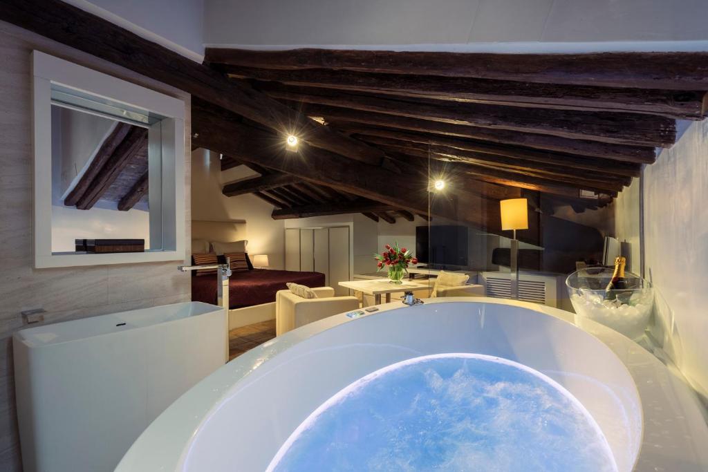 eine große Badewanne in einem Zimmer mit Wohnzimmer in der Unterkunft Gigli D'Oro Suite in Rom