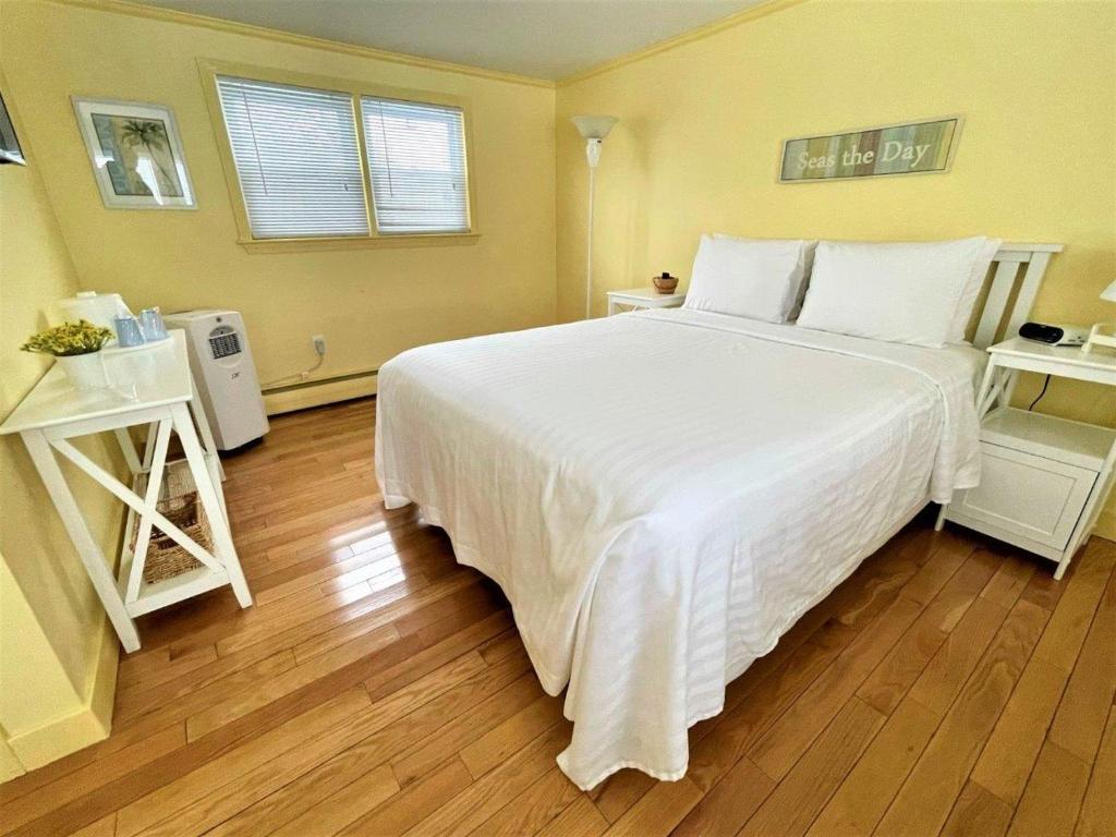 a bedroom with a large bed with white sheets at The Escape Inn in South Yarmouth