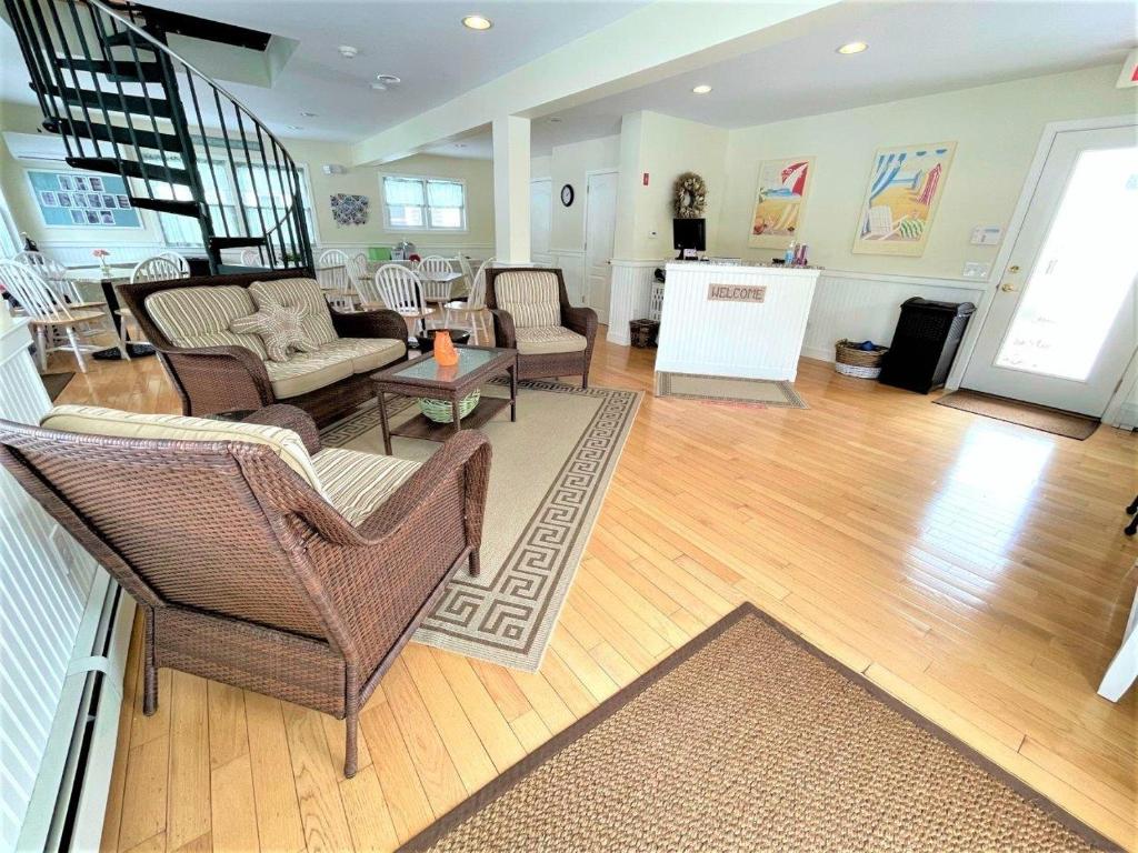a living room with wicker furniture and a staircase at The Escape Inn in South Yarmouth