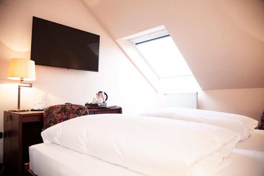 a bedroom with a bed and a tv on the wall at Hotel Lonac in Duisburg