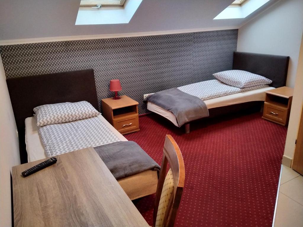 pokój z dwoma łóżkami i stołem w obiekcie VENA Noclegi Restauracja Sala Bankietowa w mieście Malanów
