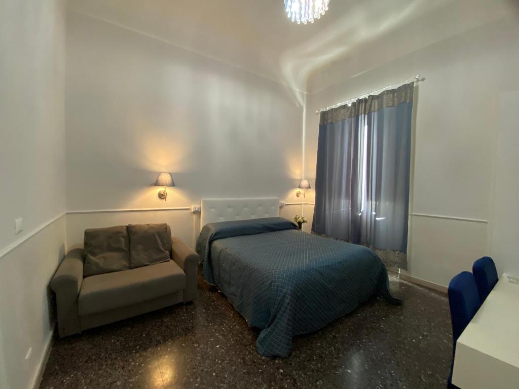 ein Schlafzimmer mit einem Bett und einem Stuhl in der Unterkunft Duomo View in Florenz