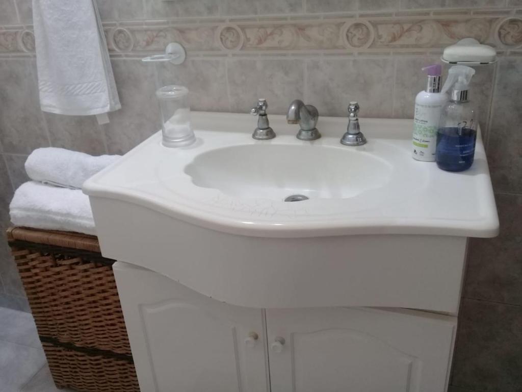 a white sink in a bathroom with towels at Casa Quinta en Luján - Olivera in Olivera