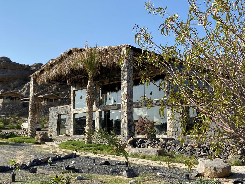 an old stone house with a grass roof at Sama Heights Resort in Dār Sawdāʼ