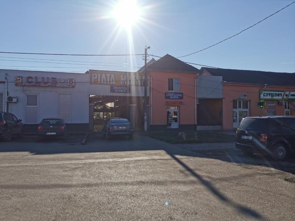 un estacionamiento con autos estacionados frente a una tienda en Hostel Maria, en Beiuş