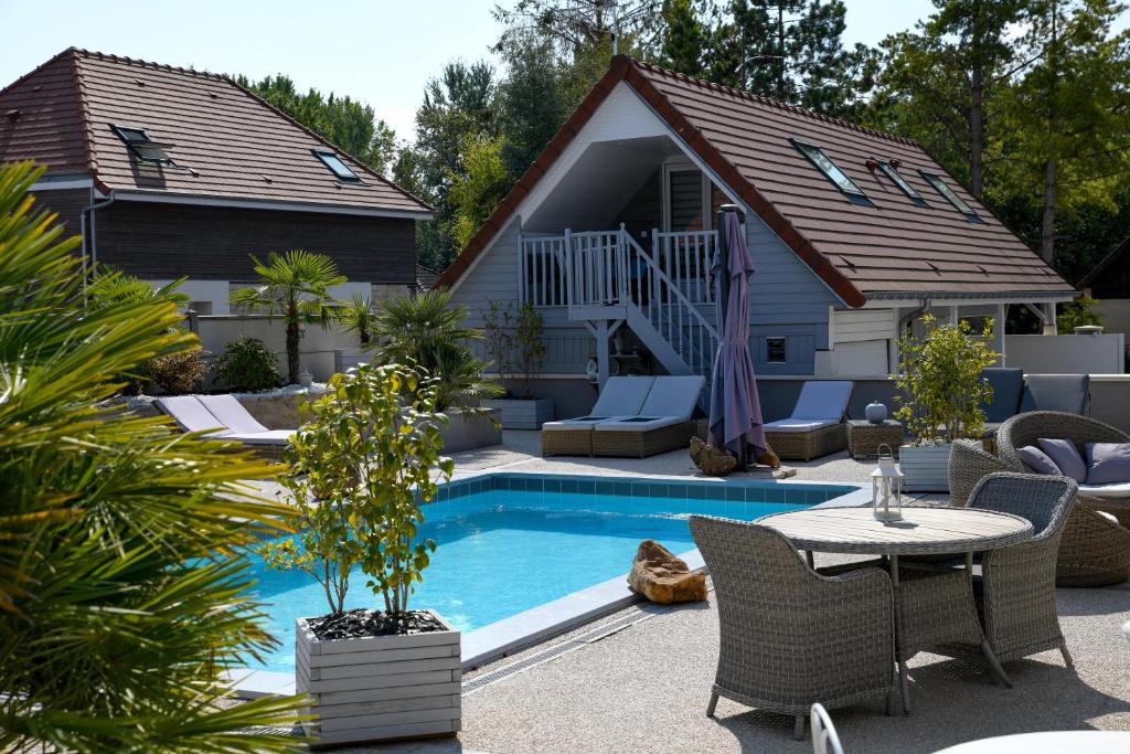 un patio trasero con piscina y una casa en Gîte de la Croix en Villechétif
