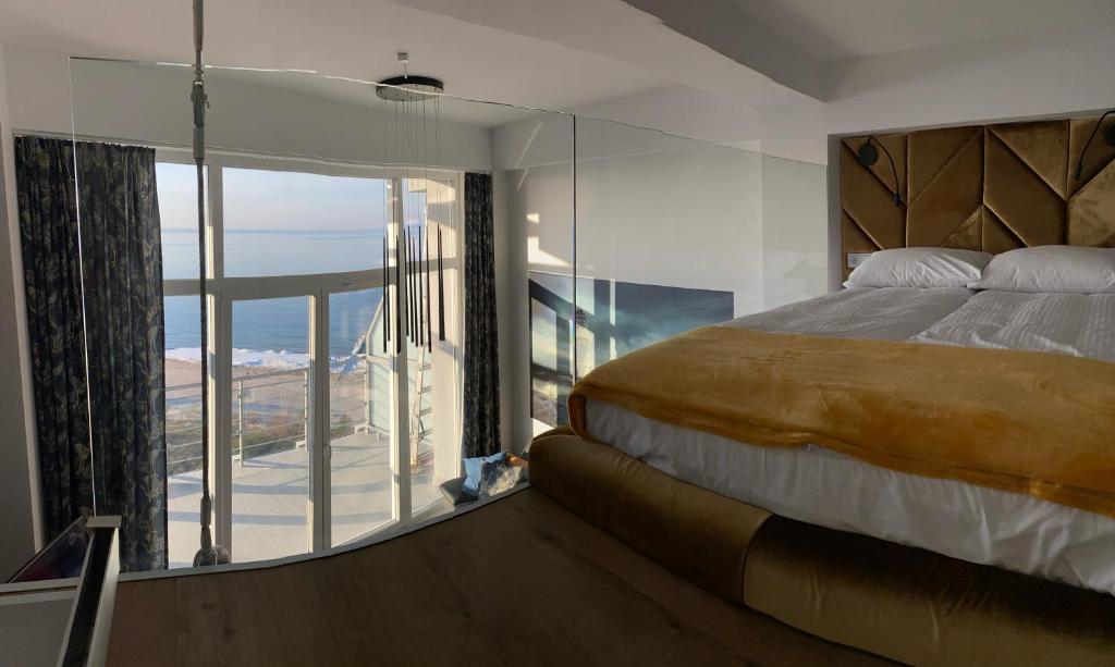 a bedroom with a large bed and a balcony at The Baltic Horizon in Dziwnówek