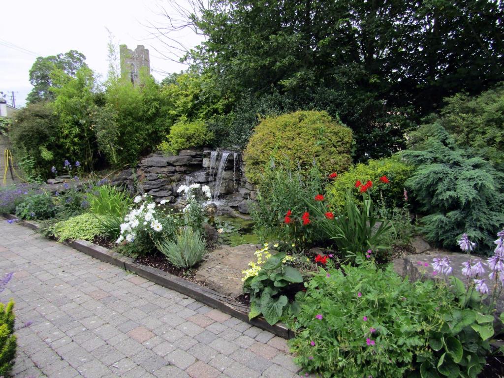 a garden with flowers and a water fountain at Darnley Lodge Hotel in Athboy