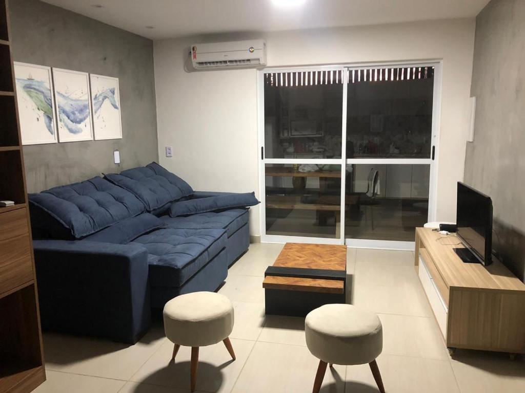 Summer Houses Itacimrim في إيتاسيميريم: غرفة معيشة مع أريكة زرقاء و كرسيين