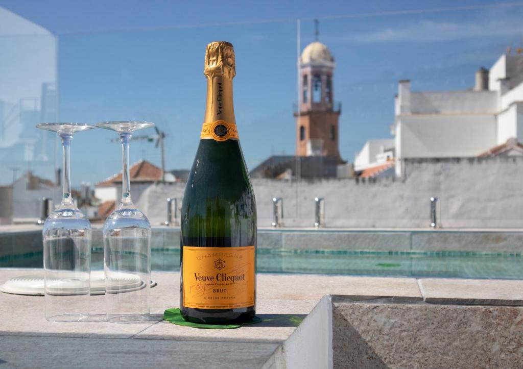 Una botella de vino sobre una mesa con dos copas. en No 17 Competa, en Cómpeta